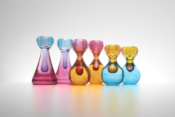 Multiple Blown Glass Candlesticks In Bright Alternating Colors Of Pink, Blue, And Orange.
