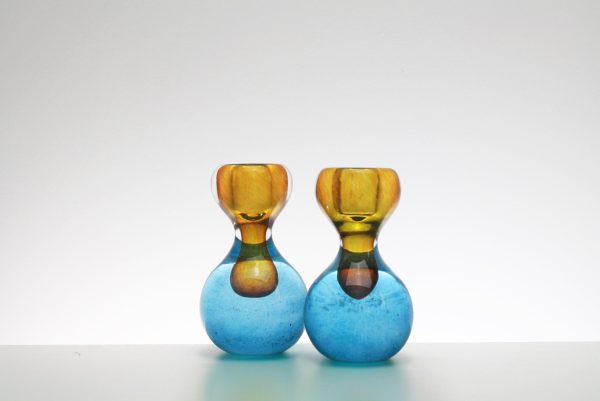 Closeup Of A Pair Of Blue And Orange Round Glass Candlesticks.